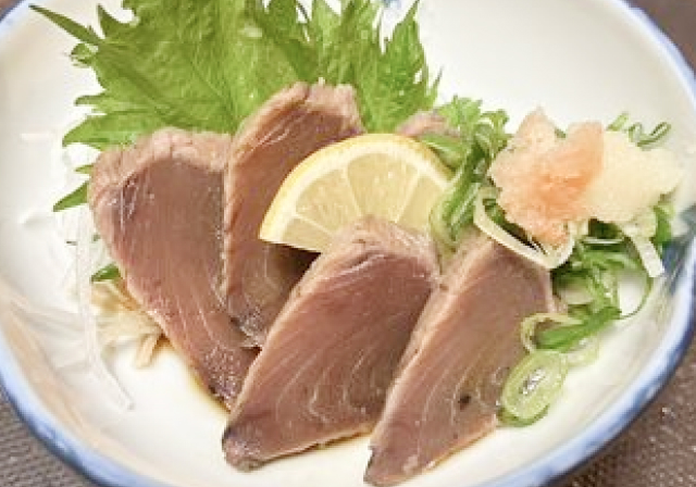 薬味とレモンが添えられたかつおのたたき